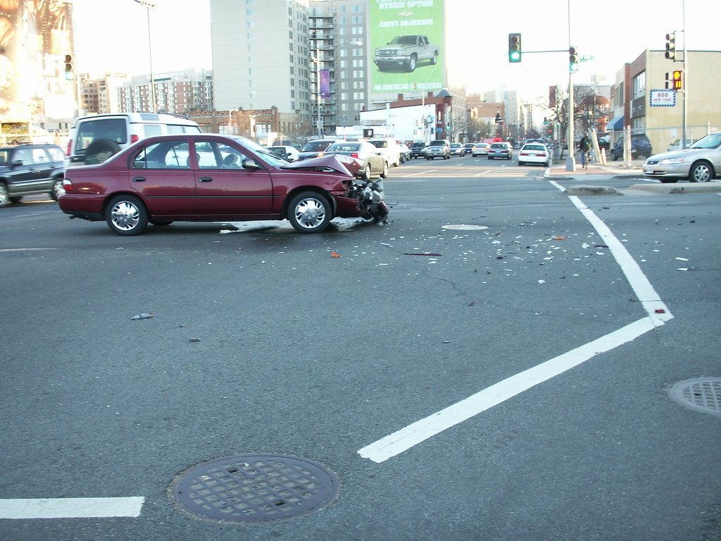 Debris scattered at a busy intersection after a collision