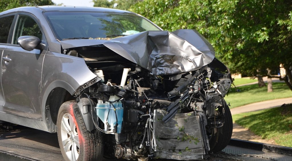 A wrecked car being loaded onto a tow truck